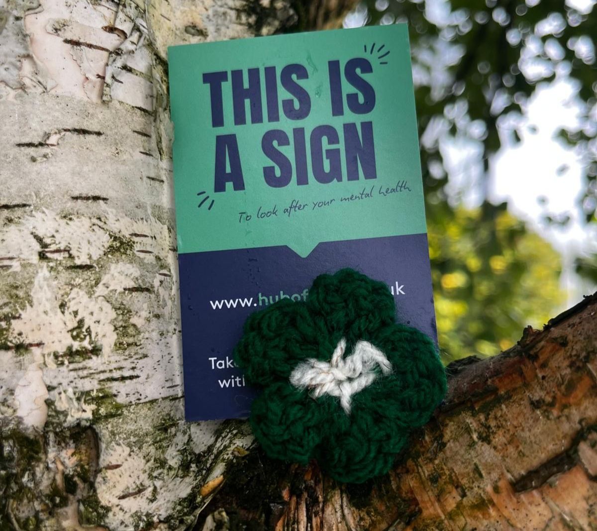 A Flower of Hope and Hub of Hope sign on a tree branch A Flower of Hope and Hub of Hope sign on a tree branch